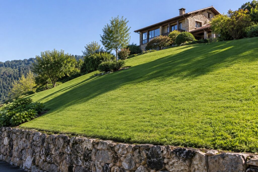 Jardín con pendiente fuerte y el césped cortado de forma uniforme en toda la ladera